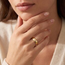 Aliança de ouro 4mm com friso e 3 brilhantes usada na mão feminina