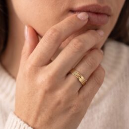 Aliança de ouro 4,5mm trabalhada com textura usada na mão feminina