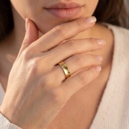Aliança de ouro 5mm quadrada anatômica com facetas usada na mão feminina